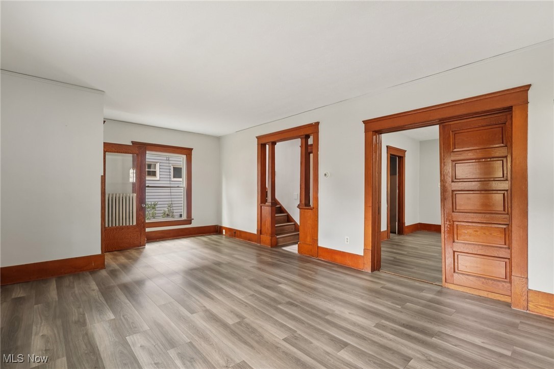 748 Chalker Street Akron, OH 44310 - Photo 13 of 48 Unfurnished room featuring wood finished floors, radiator heating unit, and stairs