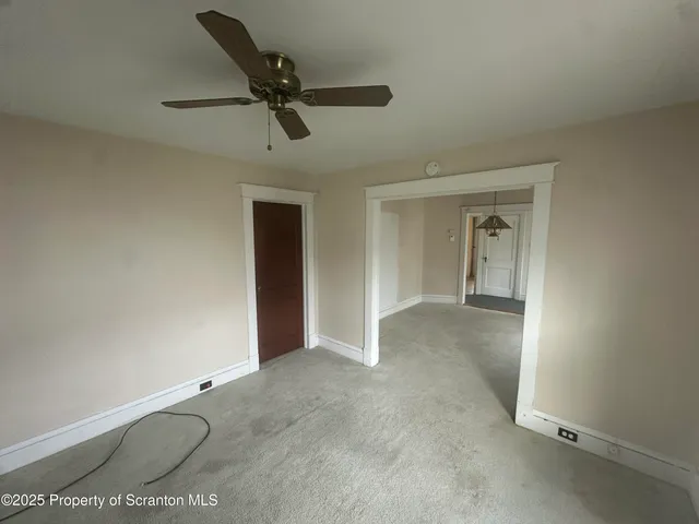 a view of a room with a ceiling fan and window