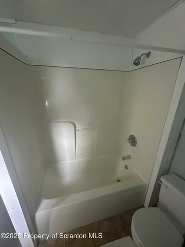 a bathroom with a shower and toilet