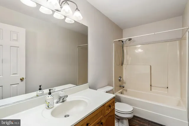 a bathroom with a sink toilet vanity and shower