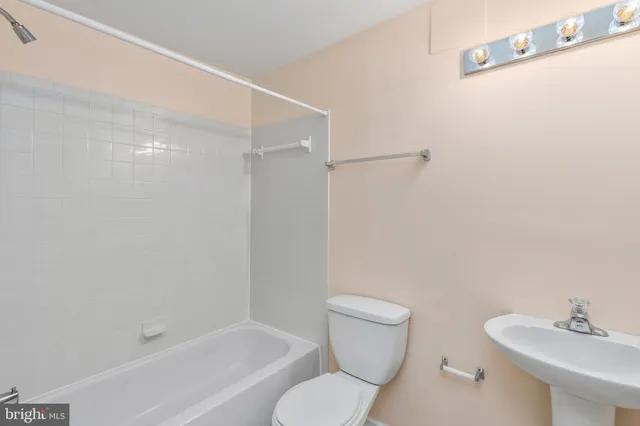 a white toilet sitting next to a bath tub