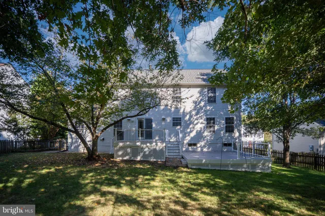 a front view of a house with a garden and tree