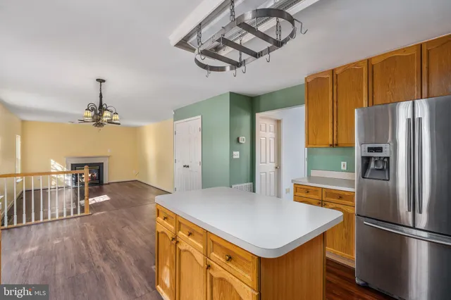 a kitchen with stainless steel appliances a table chairs refrigerator and microwave