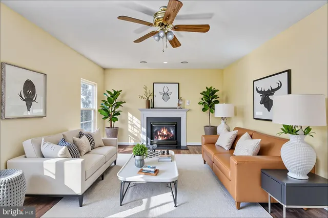 a living room with furniture a fireplace and a large window