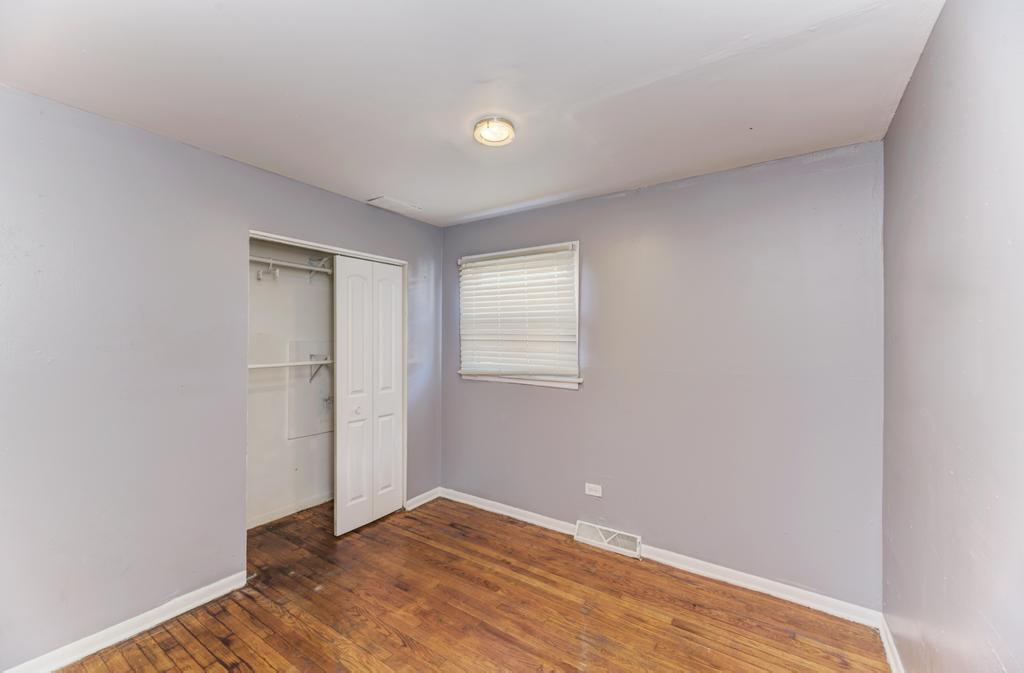 1472 West 74th Street Chicago, IL 60636 - Photo 15 of 32 a view of an empty room with wooden floor and a window