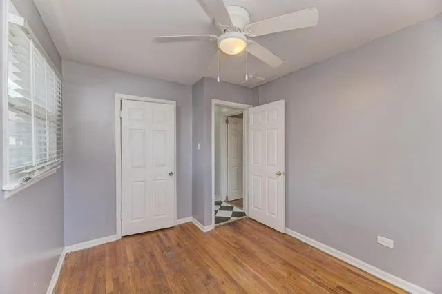 an empty room with closet and a ceiling fan