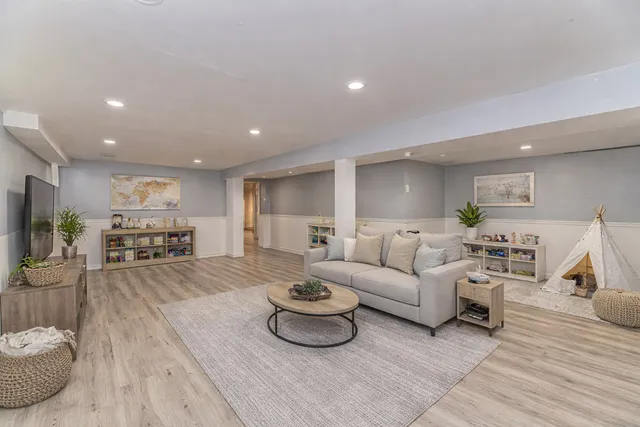 a living room with furniture a wooden floor and a sink