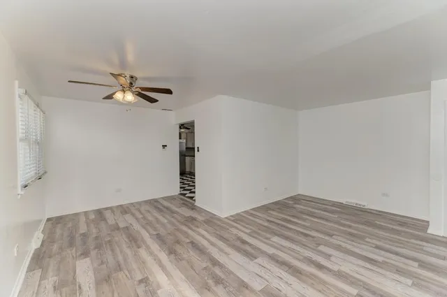 a view of empty room with wooden floor