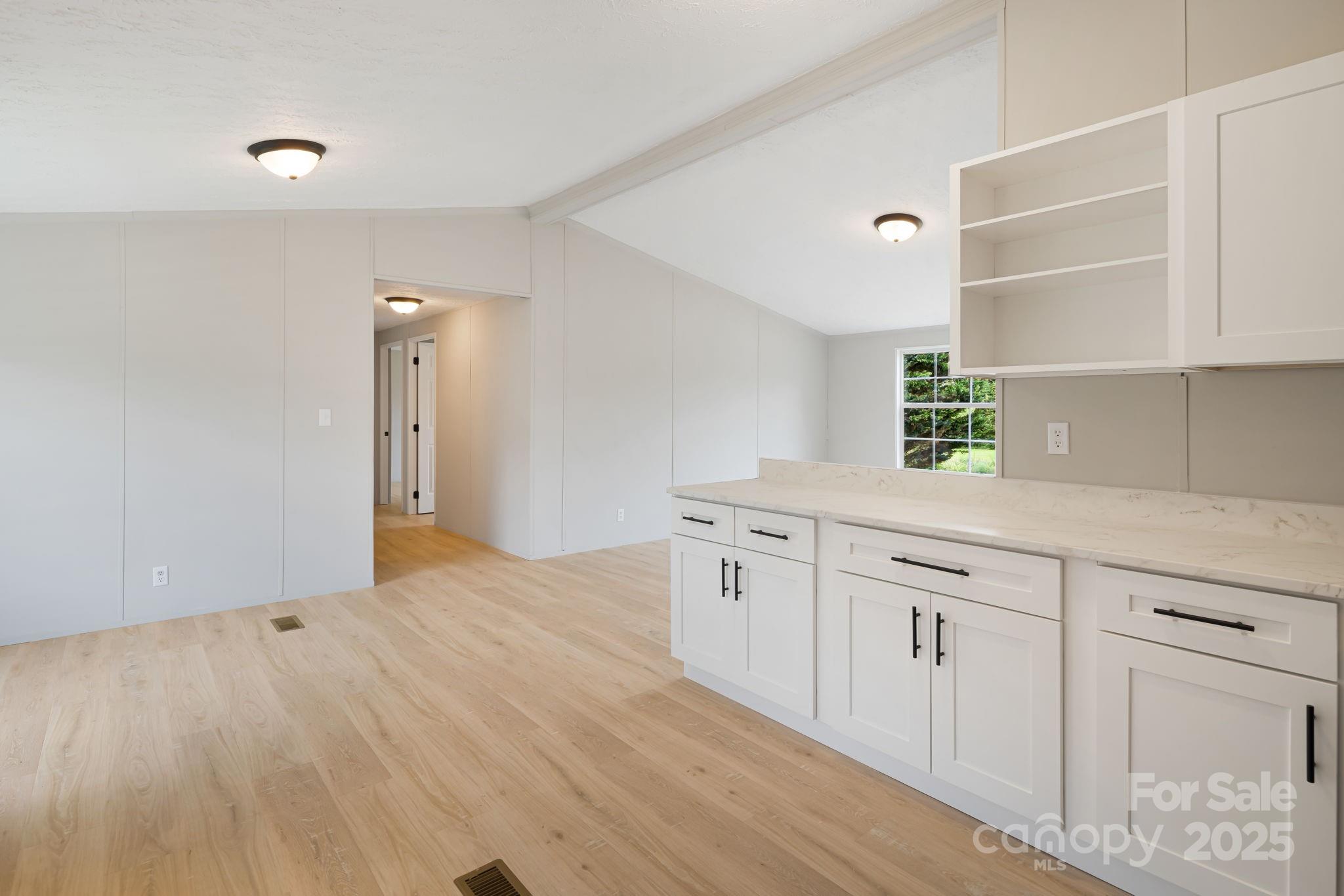 21 Toms Road Candler, NC 28715 - Photo 12 of 29 a kitchen with granite countertop a sink cabinets and wooden floor