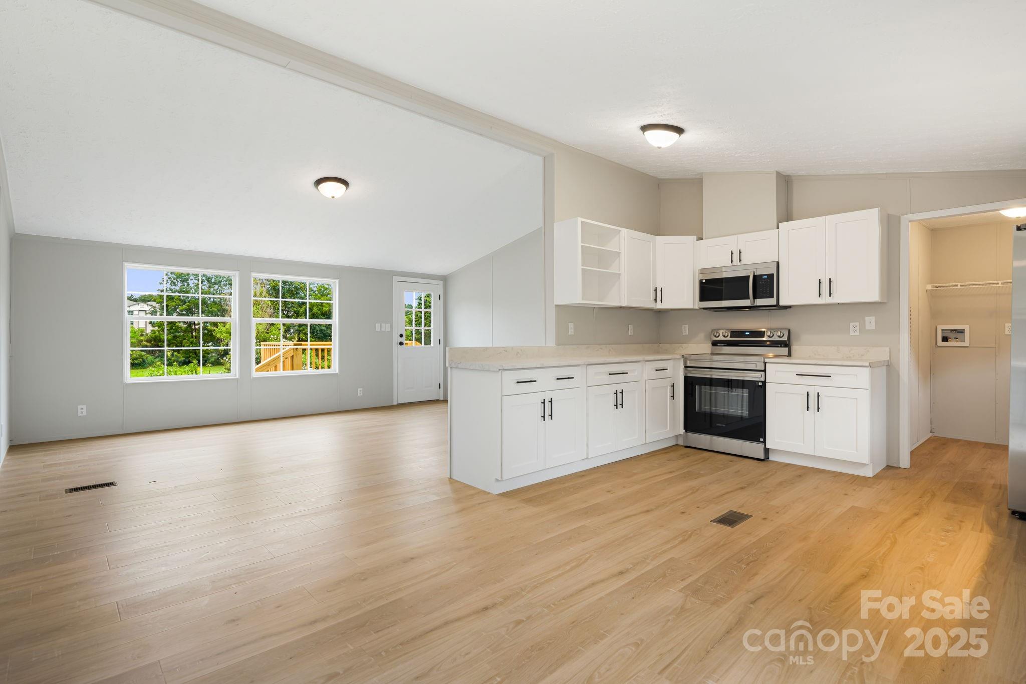 21 Toms Road Candler, NC 28715 - Photo 9 of 29 a kitchen with stainless steel appliances granite countertop a stove top oven sink and cabinets