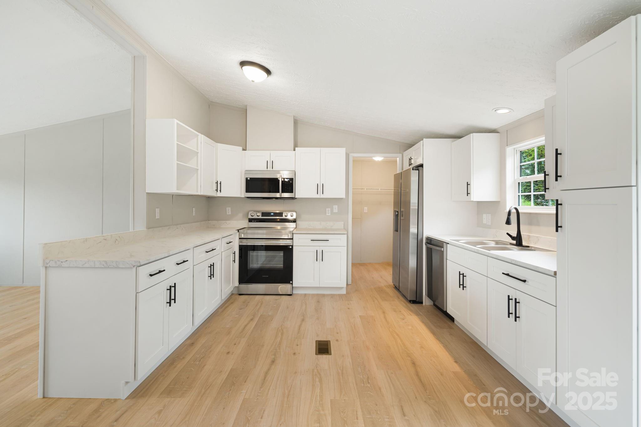 21 Toms Road Candler, NC 28715 - Photo 10 of 29 a kitchen with granite countertop white cabinets and white appliances