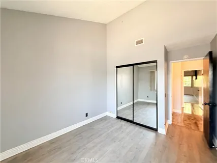 an empty room with wooden floor and mirror