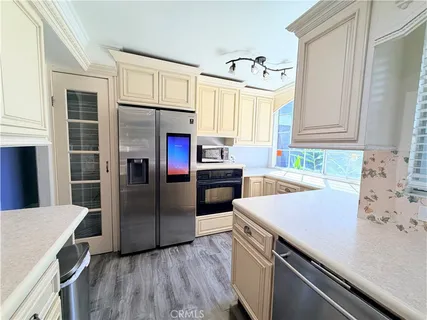 a kitchen with a sink cabinets stainless steel appliances and a window
