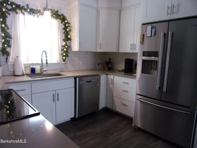 a kitchen with a refrigerator sink and cabinets