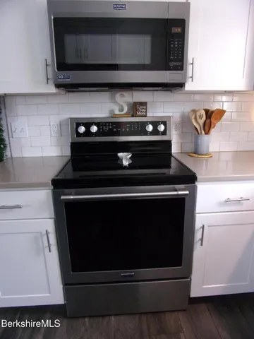 a stove top oven sitting inside of a kitchen