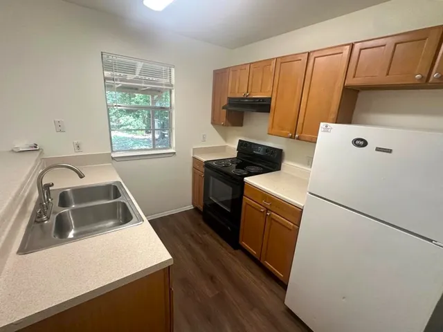 a kitchen with a refrigerator sink stove and cabinets