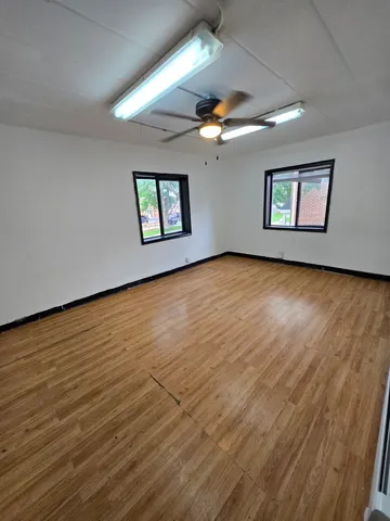 a living room with pool table and a wooden floor
