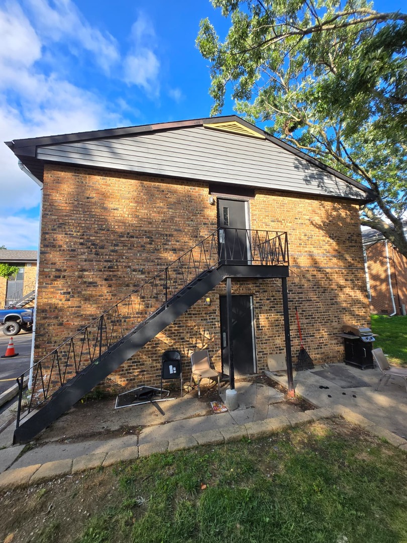 924 Greenbrier Road DeKalb, IL 60115 - Photo 16 of 20 a view of a porch with a table and chairs under an umbrella