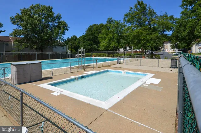 a view of a tennis court with large trees