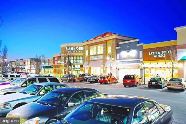 a front view of a building with cars parked