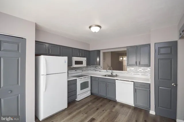 a kitchen with white cabinets and white appliances