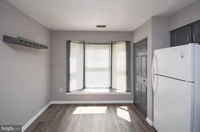 a view of a kitchen with a refrigerator cabinets and wooden floor