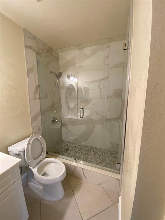 5701 Riverside Drive, Unit 302 Coral Springs, FL 33067 - Photo 14 of 21 a bathroom with a granite countertop toilet a sink a shower and a mirror