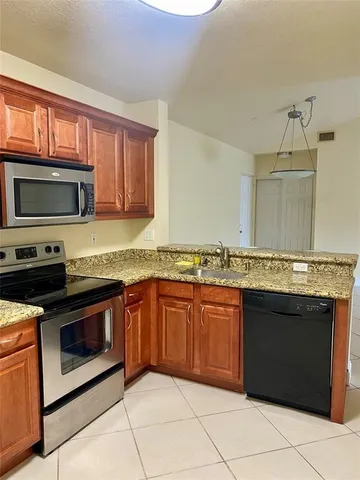 a kitchen with granite countertop a stove top oven microwave and cabinets
