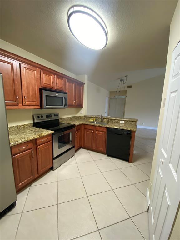 5701 Riverside Drive, Unit 302 Coral Springs, FL 33067 - Photo 6 of 21 a kitchen with stainless steel appliances granite countertop a stove a sink and a microwave