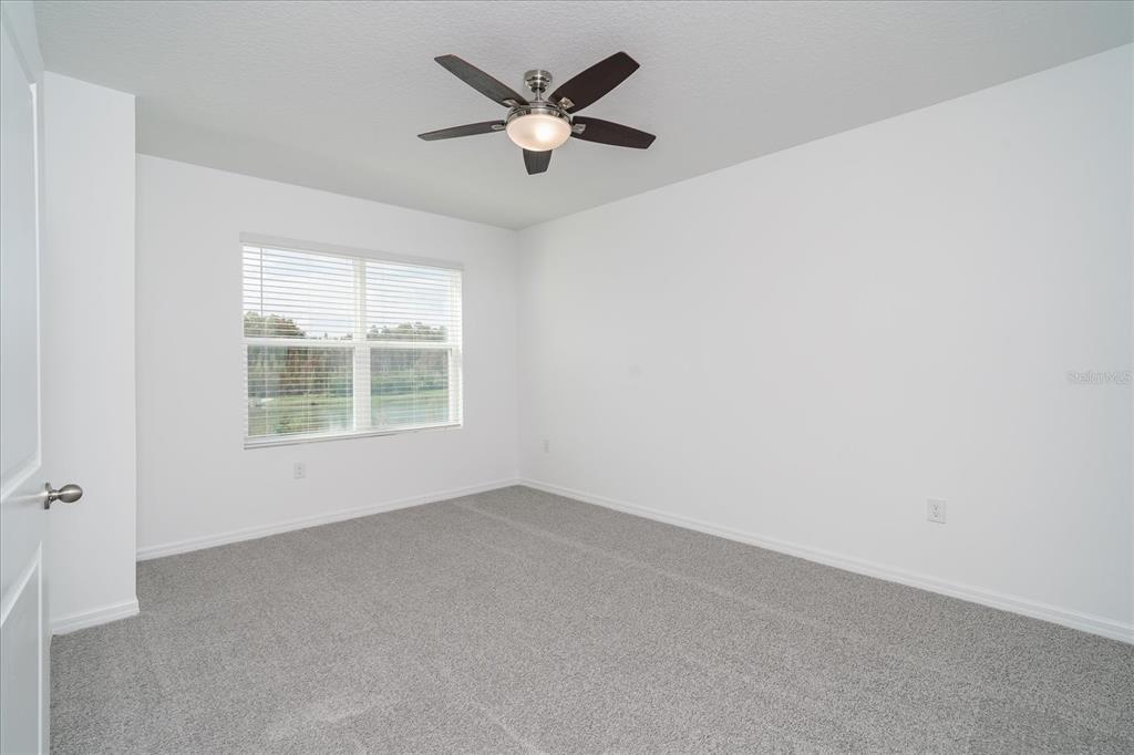 2466 Riversong Ldg Lane Wesley Chapel, FL 33543 - Photo 12 of 33 an empty room with a window and a ceiling fan