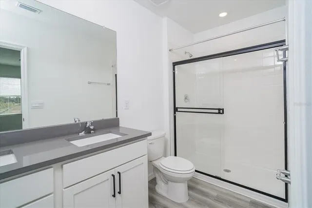 a bathroom with a granite countertop sink toilet and shower