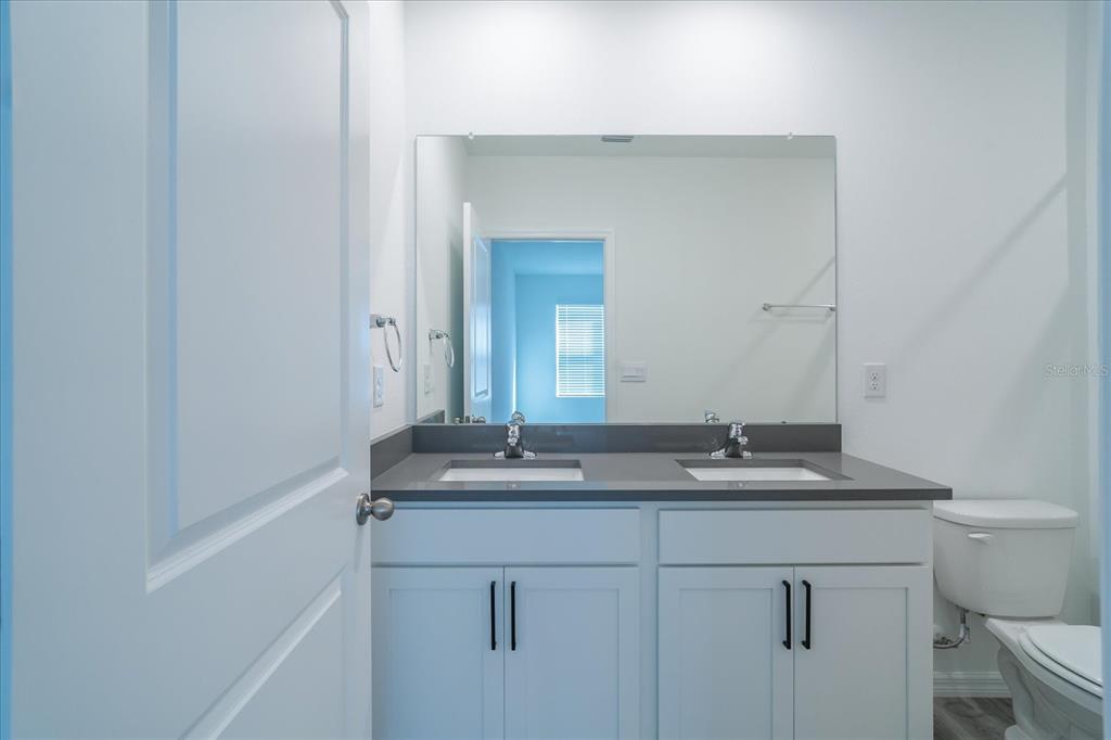 2466 Riversong Ldg Lane Wesley Chapel, FL 33543 - Photo 14 of 33 a bathroom with a granite countertop sink and a mirror
