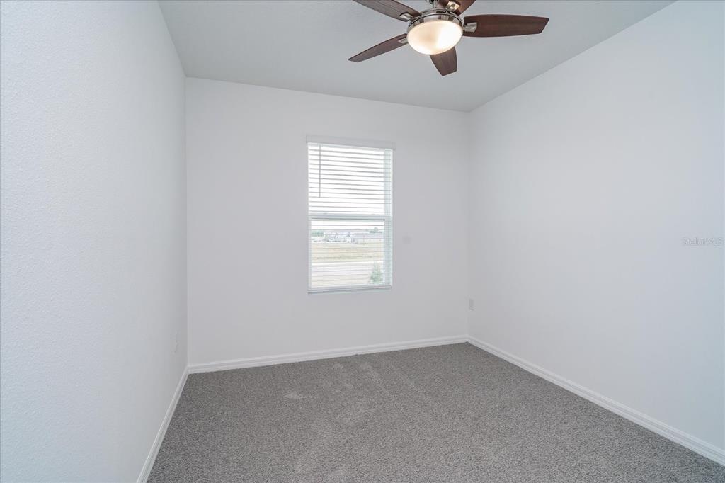 2466 Riversong Ldg Lane Wesley Chapel, FL 33543 - Photo 18 of 33 an empty room with a window and a fan
