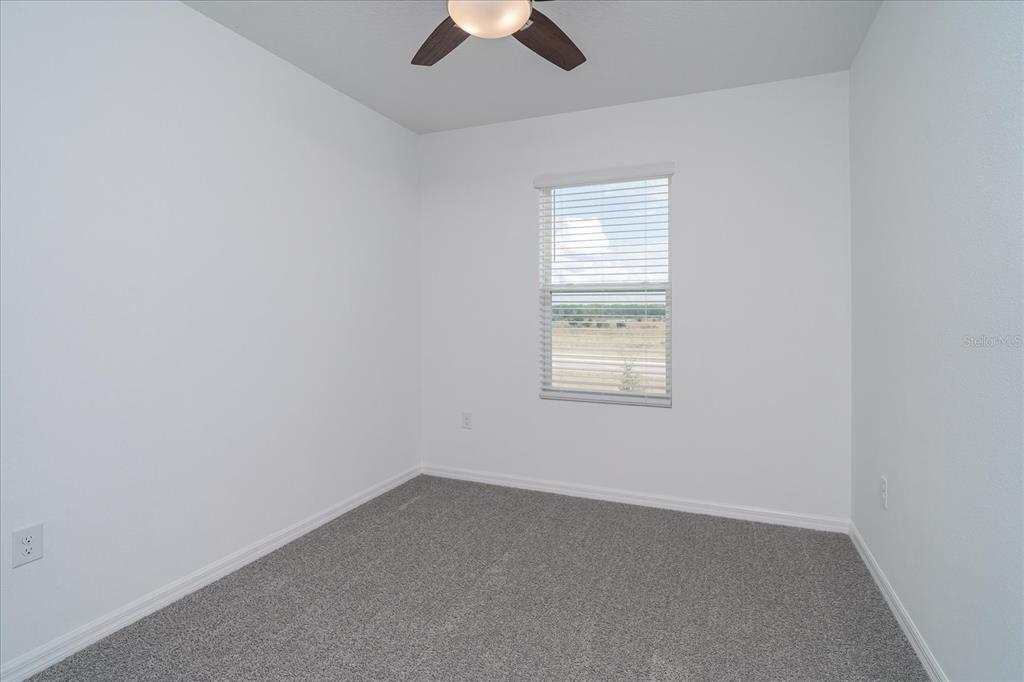 2466 Riversong Ldg Lane Wesley Chapel, FL 33543 - Photo 20 of 33 an empty room with a window and a ceiling fan