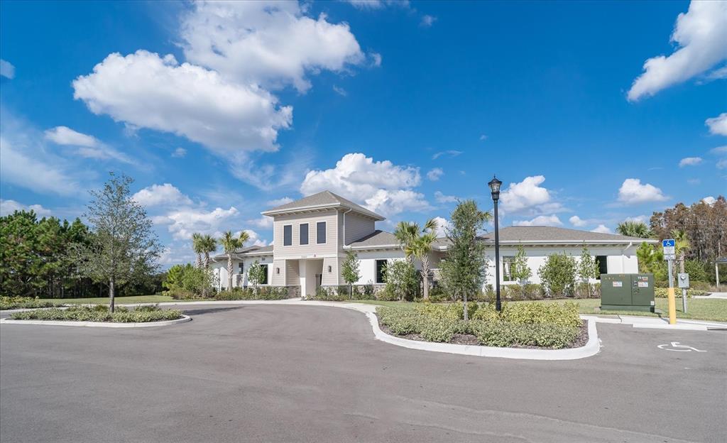 2466 Riversong Ldg Lane Wesley Chapel, FL 33543 - Photo 25 of 33 a view of a white house with a yard and potted plants