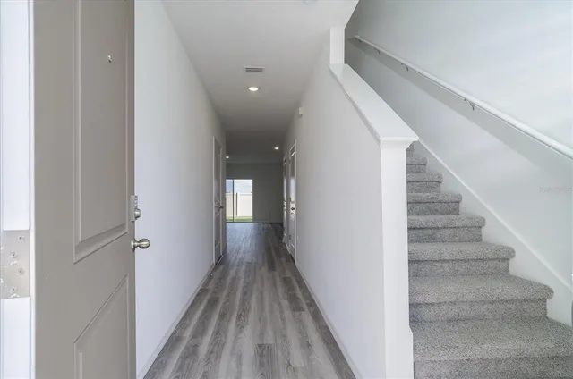 a view of a hallway with wooden floor and entryway