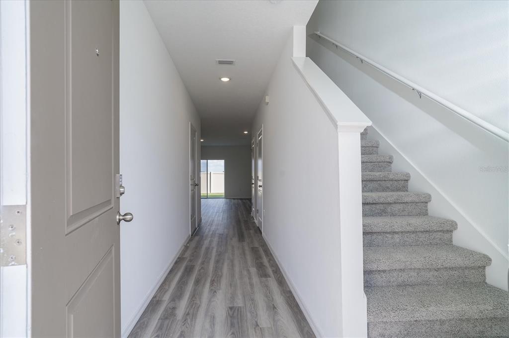 2466 Riversong Ldg Lane Wesley Chapel, FL 33543 - Photo 3 of 33 a view of a hallway with wooden floor and entryway