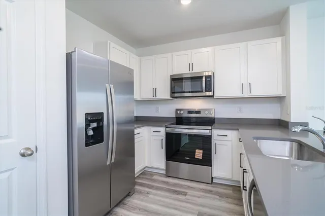 a kitchen with stainless steel appliances granite countertop a refrigerator stove and sink