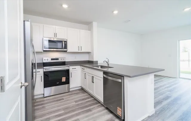 a kitchen with stainless steel appliances a stove microwave and sink