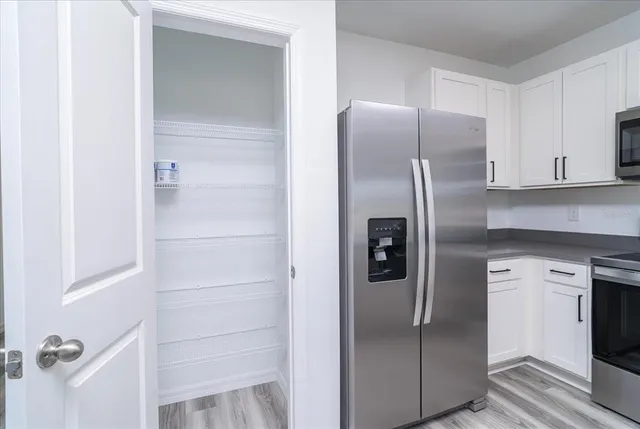 a metallic refrigerator freezer sitting in a kitchen
