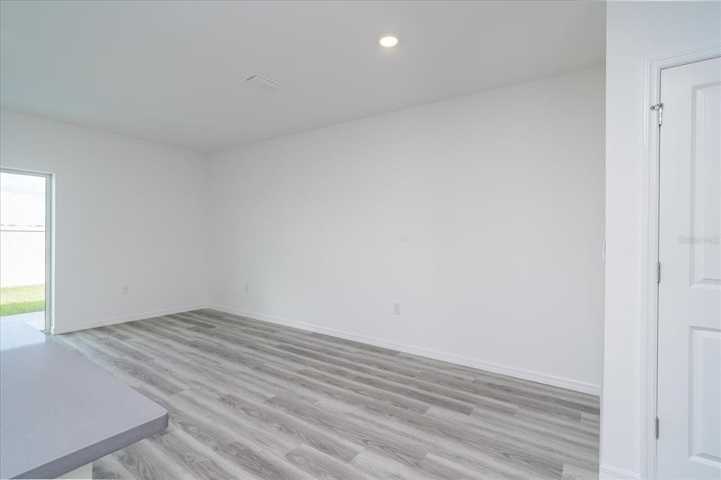 2466 Riversong Ldg Lane Wesley Chapel, FL 33543 - Photo 9 of 33 an empty room with wooden floor and windows