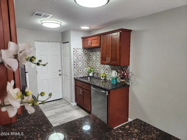 a hallway with a stove a refrigerator and a potted plant