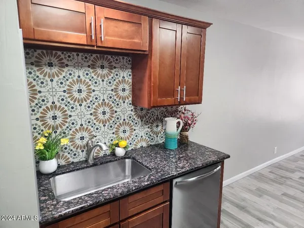 a kitchen with granite countertop a sink and a wooden cabinets