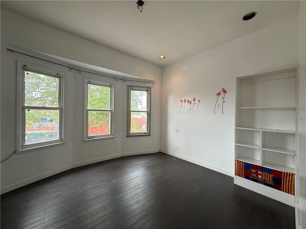 133 Quentin Road Brooklyn, NY 11223 - Photo 11 of 12 an empty room with wooden floor and windows