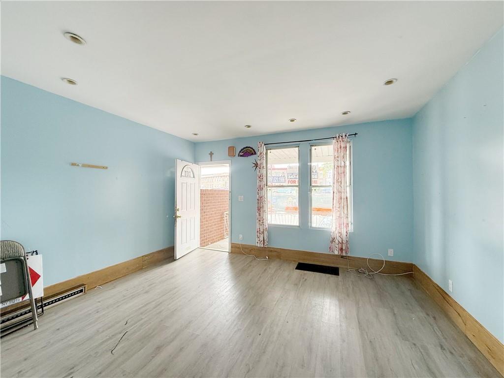 133 Quentin Road Brooklyn, NY 11223 - Photo 3 of 12 an empty room with wooden floor and windows