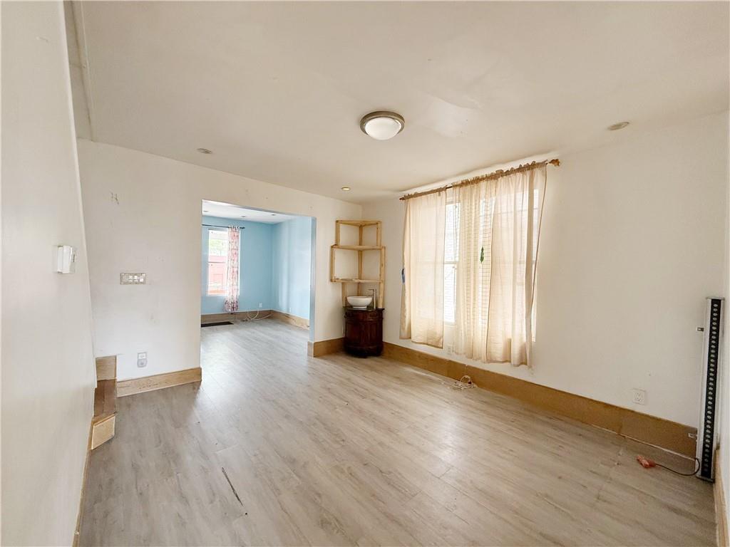 133 Quentin Road Brooklyn, NY 11223 - Photo 4 of 12 an empty room with wooden floor and windows