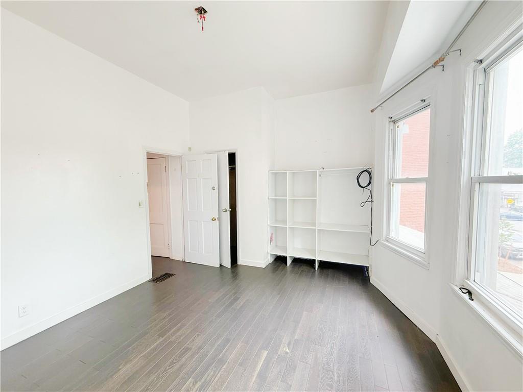 133 Quentin Road Brooklyn, NY 11223 - Photo 9 of 12 an empty room with wooden floor and window