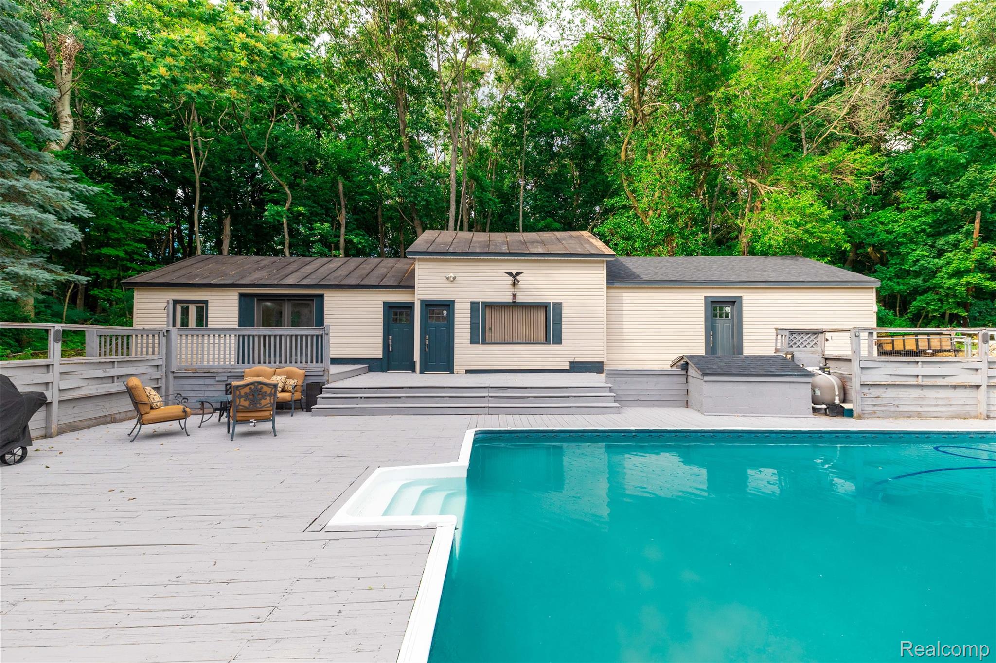 4860 Blue Bush Road Monroe, MI 48162 - Photo 42 of 59 Backyard oasis featuring a large inground pool with integrated steps, a spacious multi-level deck, and a detached structure with multiple entries
