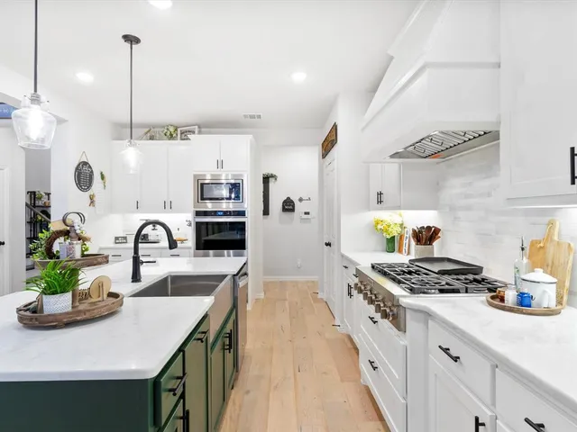 a kitchen with kitchen island stainless steel appliances a sink stove and refrigerator