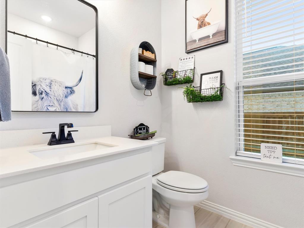 2156 Cloverfern Way Haslet, TX 76052 - Photo 17 of 40 a bathroom with a toilet a sink and mirror
